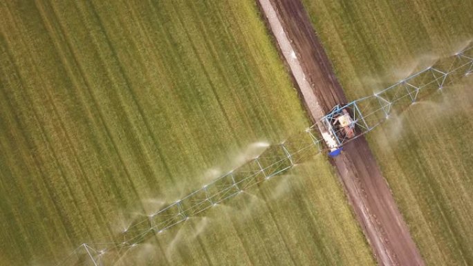 农用拖拉机喷洒农田的空中无人机拍摄。