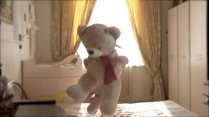 泰迪熊和女孩因跳上床而高兴地摔倒而高兴。女孩8岁欧洲外观