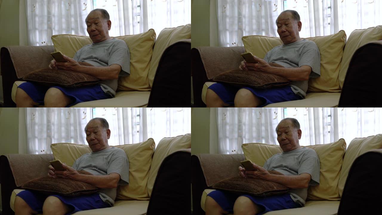 老人坐在沙发上看手机