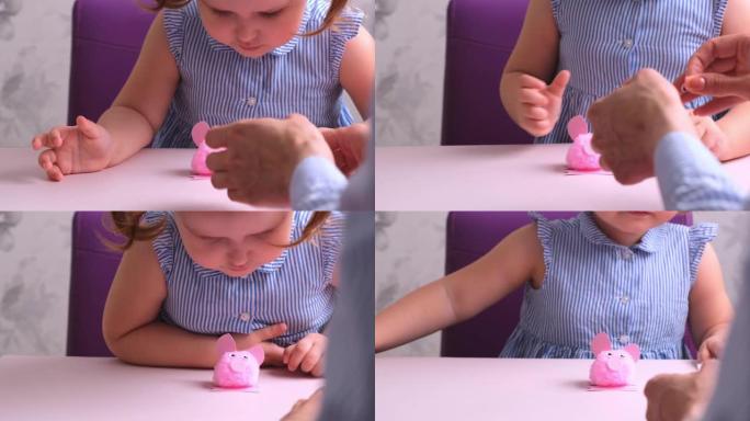 小女孩和她的母亲一起做了一个柔软的玩具粉红猪。日常妈妈，带孩子的手艺