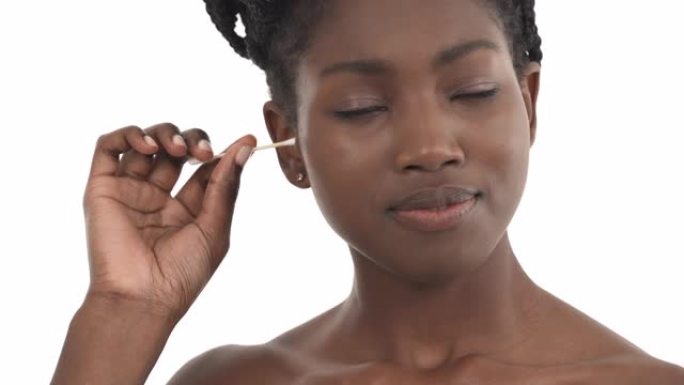 年轻的非洲裔美国女孩用棉芽清洁耳朵的特写肖像。孤立在白色背景上。日常卫生。