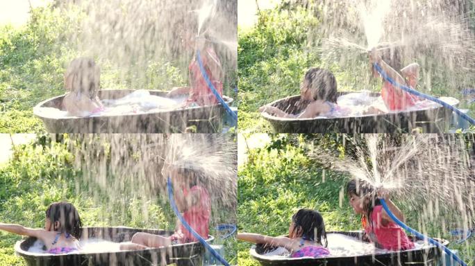 两个亚洲女孩用水管和喷雾清理她的玩具狮子狗