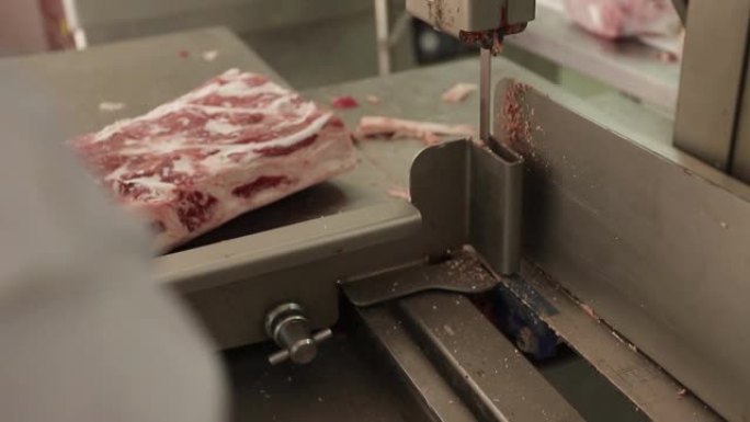 牛肉或猪肉的解剖。屠夫在食品工业中折腾骨头。肉店切肉。机器切肉。