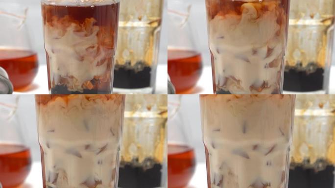制作珍珠奶茶，将混合牛奶和茶倒入白木桌上红糖图案的玻璃杯中背景