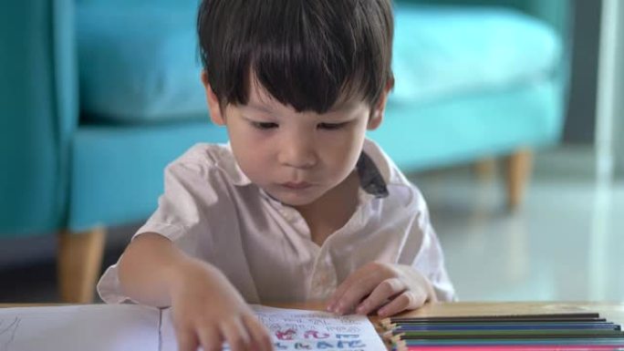 男孩画在泰国文字上，适合教与学的材料。