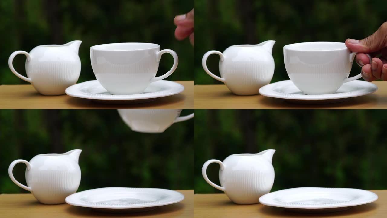 老人的手举起一杯白色陶瓷杯咖啡喝。