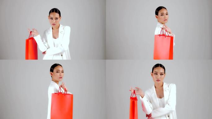 美丽的亚洲现代外观女商人拿着红色购物袋，看着相机