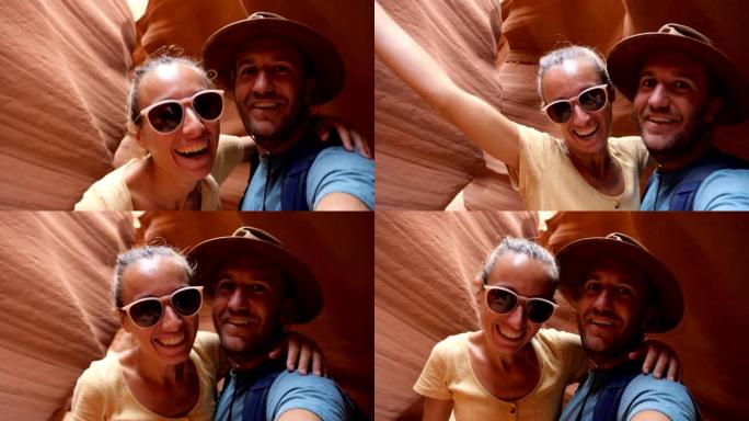 年轻夫妇在美国羚羊峡谷自拍。夫妇在沙漠狭窄的峡谷里徒步旅行自拍