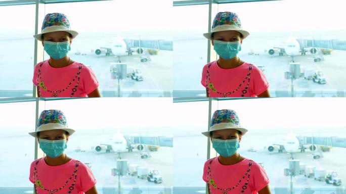 在机场，戴着医用防护面具的女童肖像，在全景窗前，可看到跑道和大平面视图。冠状病毒疫情结束后，航班重新