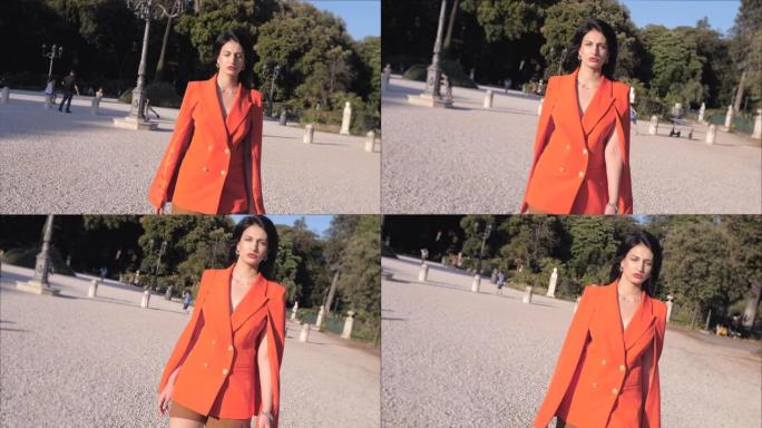 穿着橙色夹克的性感美女在罗马平西奥散步