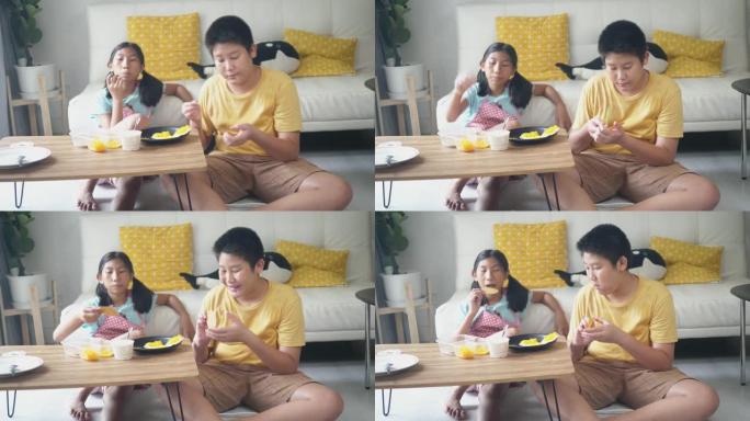 快乐的亚洲男孩和他的妹妹在零食上传播奶油，在家一起吃饭，生活方式理念。