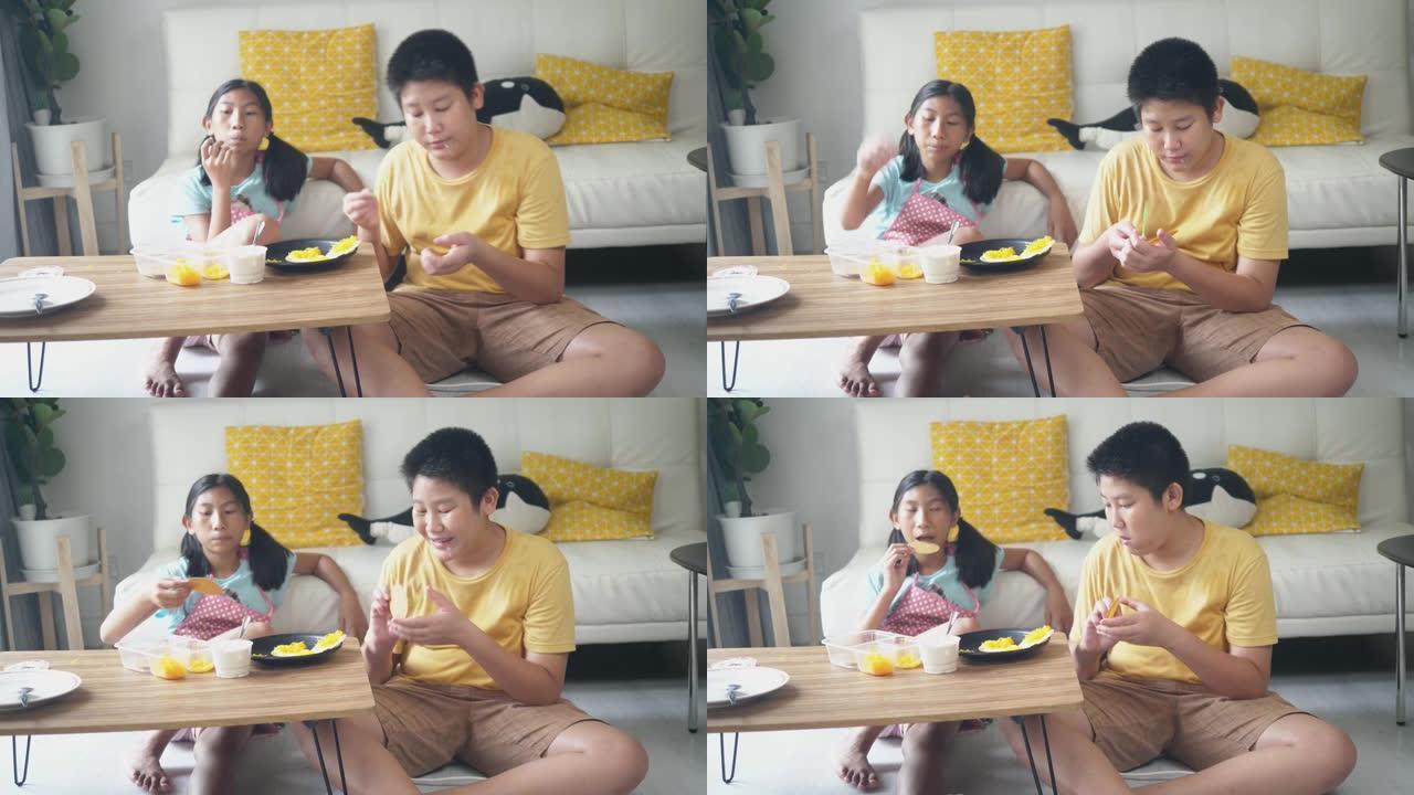 快乐的亚洲男孩和他的妹妹在零食上传播奶油，在家一起吃饭，生活方式理念。
