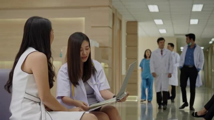 亚洲医生在医院里咨询健谈的女病人。专科医师为人民服务心灵。工作场所清洁，没有冠状病毒。结束隔离，返回
