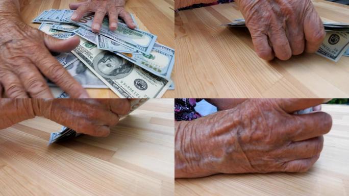 祖母的手臂从桌子上耙出散落的100美元钞票。皱巴巴的女性双手从桌子上拿出一堆堆的外币。俯视图多莉拍摄