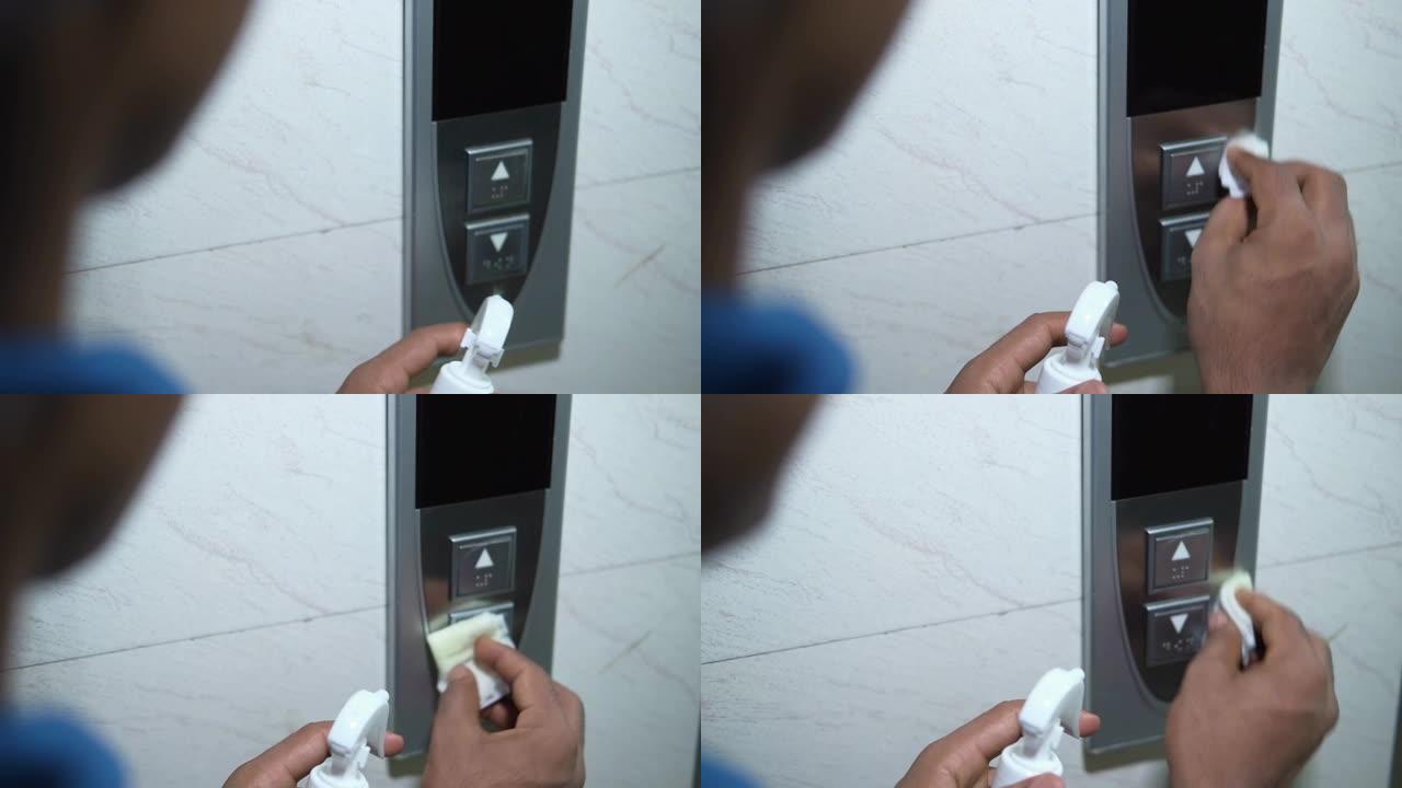 男人用手擦拭电梯按钮。