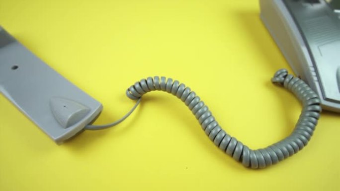 带手机和黄色灰色螺旋线的有线电话