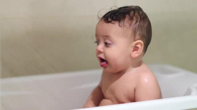 给可爱的宝宝洗澡。在浴缸里洗可爱的小孩