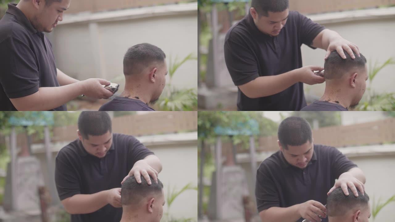 年轻的亚洲男性在家里从哥哥那里理发。