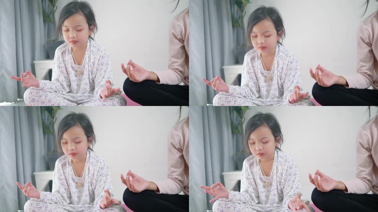 快乐的亚洲女孩和她的妹妹一起在家做冥想，生活方式理念。