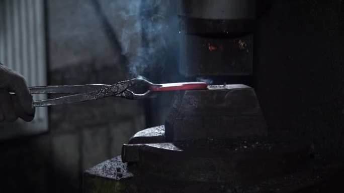 铁匠在液压机下锻造热铁