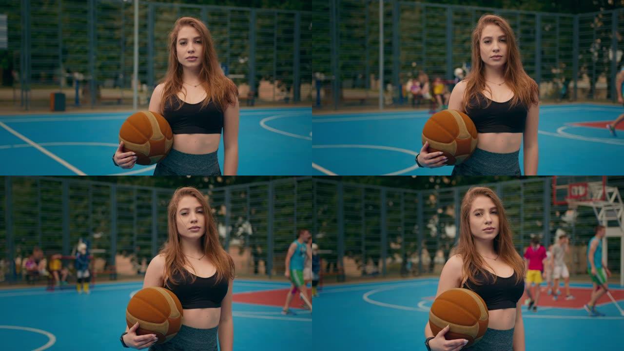 近距离射击。一个运动女孩的肖像。那个女孩正看着照相机。她拿着一个篮球。照相机在圆周运动。4 k \