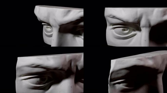 史诗工作室用戏剧性的灯光拍摄石膏头的特写镜头。一个人的白色雕像的一半脸上的光与影的玩耍。严厉的眼睛。