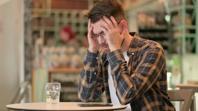 坐在咖啡馆里头痛的担心年轻人