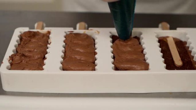 专业糖果商用波普镰刀棒将巧克力从袋管中挤压成蛋糕模具