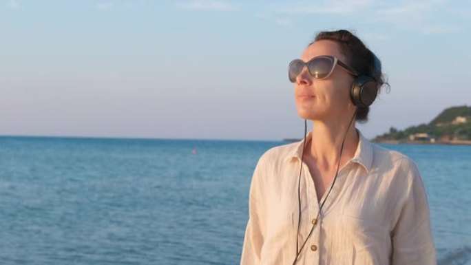海滩上戴着耳机的女人。