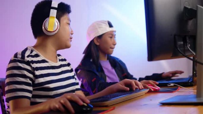 快乐的亚洲男孩和女孩在家里用led灯玩网络游戏，生活方式的概念。