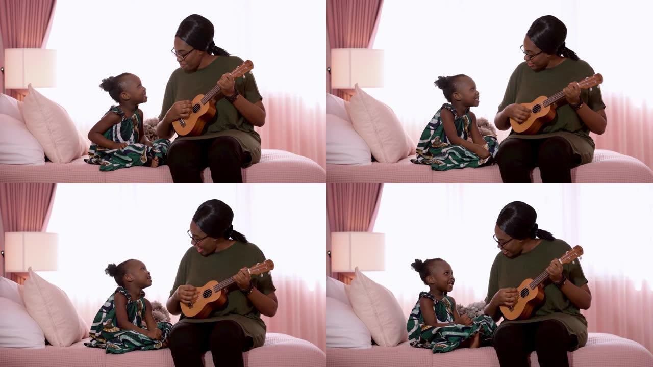 快乐的家庭非洲母亲和孩子一起唱歌和弹吉他，同时坐在卧室的床上。