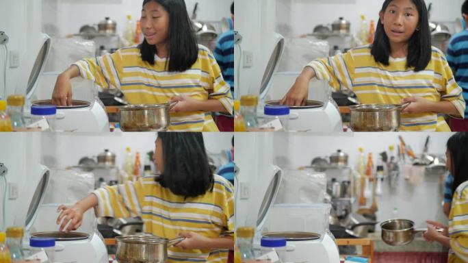 亚洲女孩在家厨房煮饭，女孩帮妈妈准备食物。
