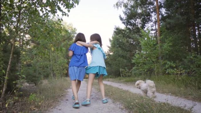 两个可爱的女孩在森林路上散步，说话