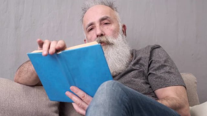 大胡子老人在沙发上看书