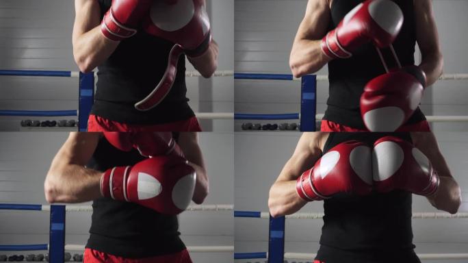 拳击手男子在格斗训练中戴上红色拳击手套。在健身房的拳击场上戴着红色手套的特写战士。跆拳道准备训练。