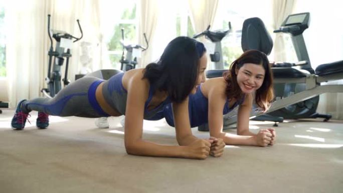 两名亚洲女性在运动服训练锻炼和练习瑜伽，教练为健康的生活方式。