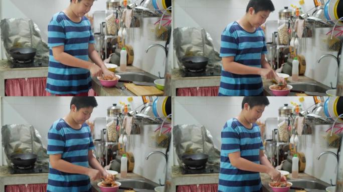 亚洲青春期男孩在家厨房里用大豆汤腌制鸡肉，生活方式概念 ..