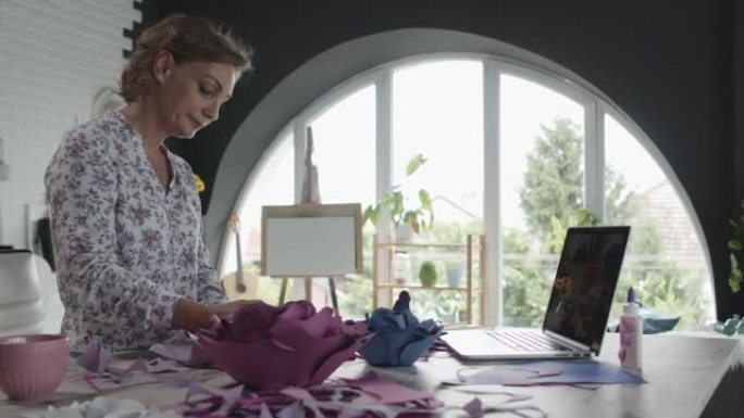 女人在做工艺品时在笔记本电脑上看教程