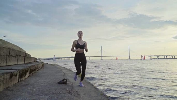 女运动员跑步的正面跟进镜头。日落时分，适合户外慢跑的女人。