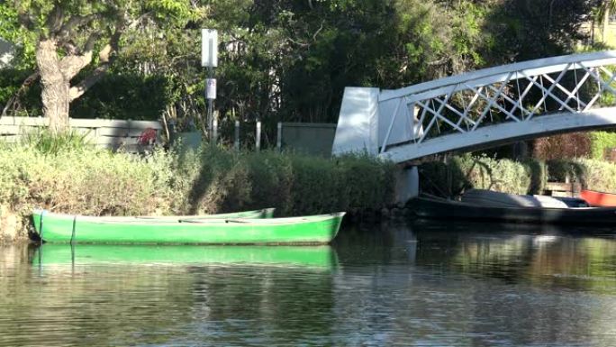 一条绿色的划艇被运河中的桥梁绑住