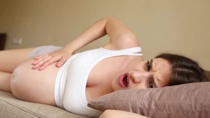 孕妇在沙发上，宫缩开始时感到疼痛