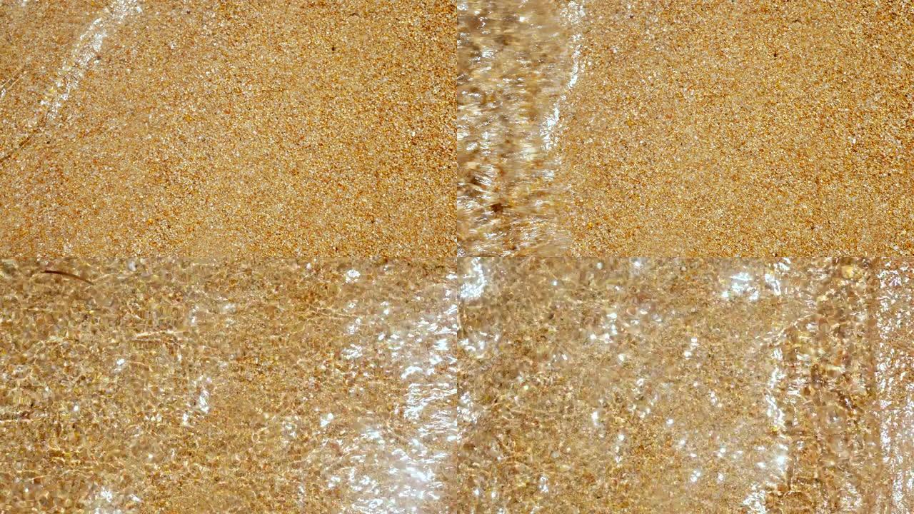 特写，清澈的海水，黄色的湿沙。太阳的光线和光线在水中反射
