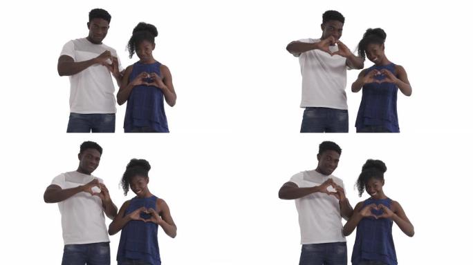 微笑的非洲裔美国夫妇的肖像用双手手指形成心形，并在白色背景上孤立地向相机展示。手心爱心标志