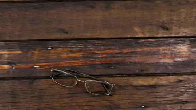 现代眼镜躺在旧的木制表面上。缩放。