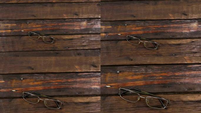 现代眼镜躺在旧的木制表面上。缩放。