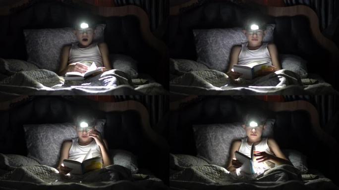 小男孩在床上用手电筒看书
