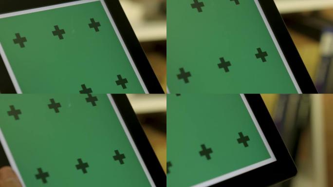 男性双手使用平板电脑，屏幕在绿色背景和跟踪点。