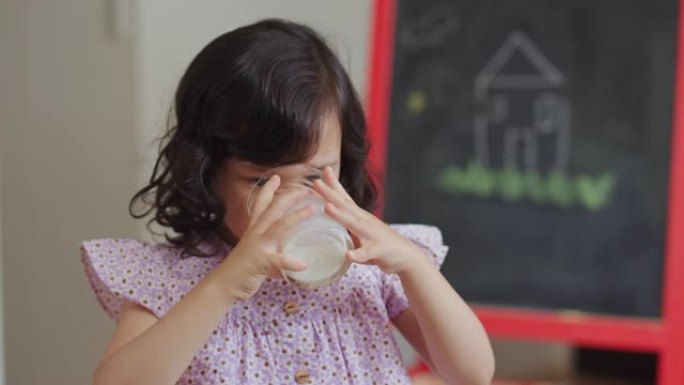 一个年轻女孩喝牛奶的特写