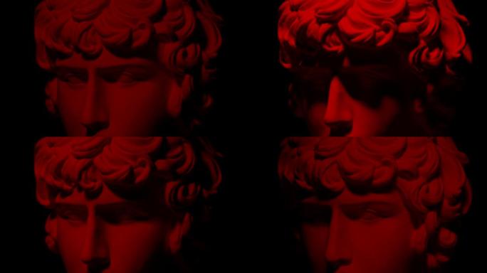 史诗工作室的石膏头特写镜头，带有移动和变化的红色照明。一个人雕像一半脸上的光影玩耍。在黑色背景上隔离