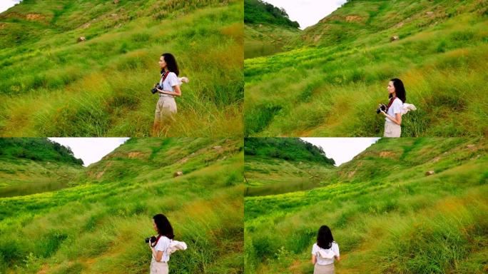 年轻的亚洲女旅行者正在欣赏高山和绿色田野的美丽风景。